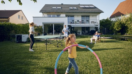 Bauen und Kaufen Finanzierungsmöglichkeiten Familie spielt im Garten