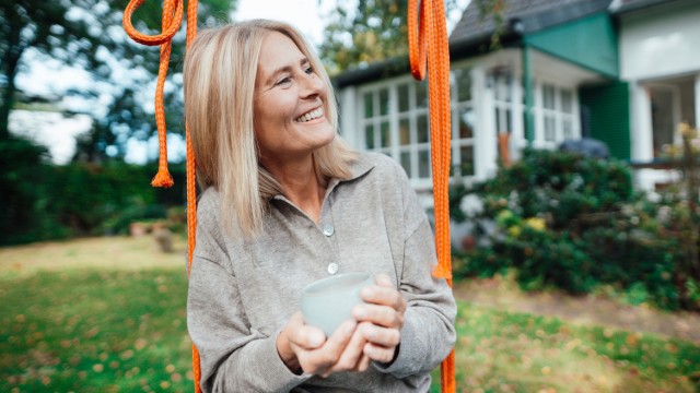 Eine Frau im Garten freut sich über den umfangreichen Service der Wüstenrot Energieberatung Eine Frau im Garten freut sich über den umfangreichen Service der Wüstenrot Energieberatung