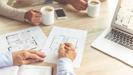 Ein Berater von Wüstenrot Immobilien plant mit Kunden den Grundriss deren Hauses Ein Berater von Wüstenrot Immobilien plant mit Kunden den Grundriss deren Hauses