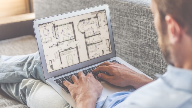 Alles, was Sie sonst bei der Wohnungssuche noch bedenken müssen, haben wir hier für Sie gesammelt. Mann schaut sich den Grundriss einer Immobilie auf seinem Laptop an