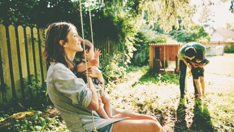 Eine Familie verbringt Zeit im Garten des Hauses, das sie mit einem Bausparvertrag finanziert haben Eine Familie verbringt Zeit im Garten des Hauses, das sie mit einem Bausparvertrag finanziert haben