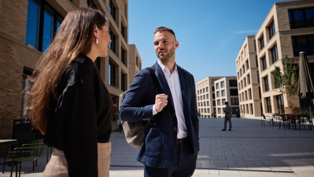 Ein W&W-Mitarbeiter und eine W&W-Mitarbeiterin unterhalten sich am W&W-Campus Ein W&W-Mitarbeiter und eine W&W-Mitarbeiterin unterhalten sich am W&W-Campus