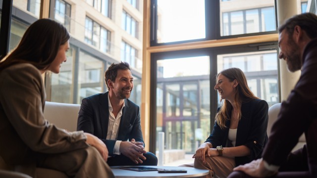 Mitarbeiter bei Wüstenrot unterhalten sich miteinander am Tisch Mitarbeiter bei Wüstenrot unterhalten sich miteinander am Tisch